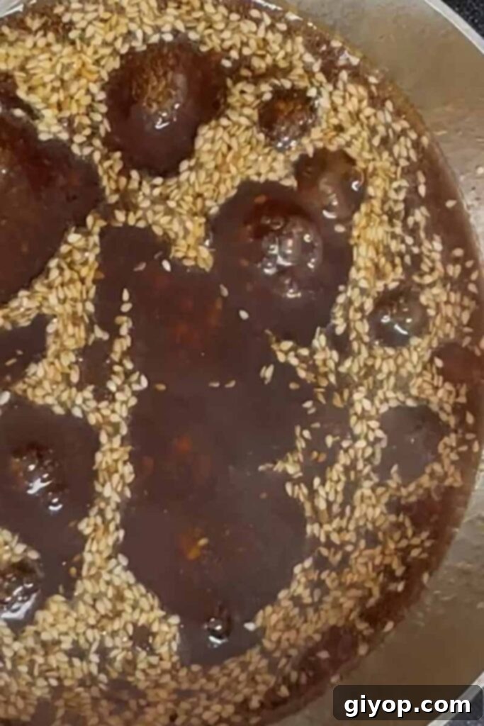 Sticky Crispy Teriyaki Chicken Thighs 8 Toasted sesame seeds being stirred into a rich teriyaki sauce.