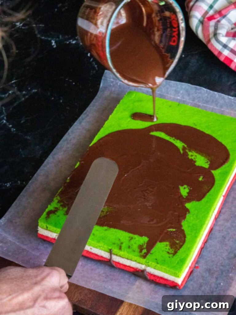 Chocolate being spread over the top of the green layer.