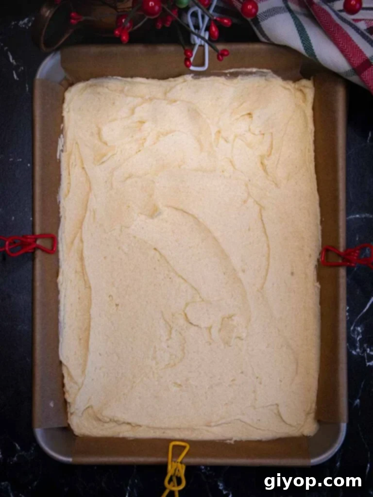 White cookie dough in the parchment paper lined pan.