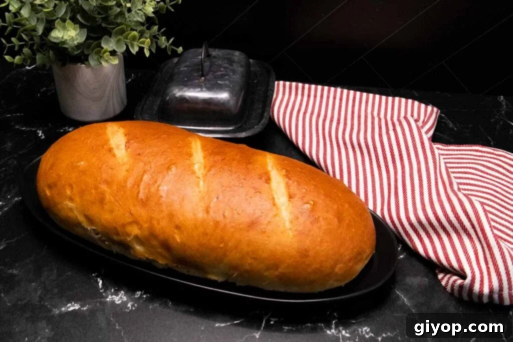 A baked loaf of Italian bread with a golden-brown crust on a cutting board.