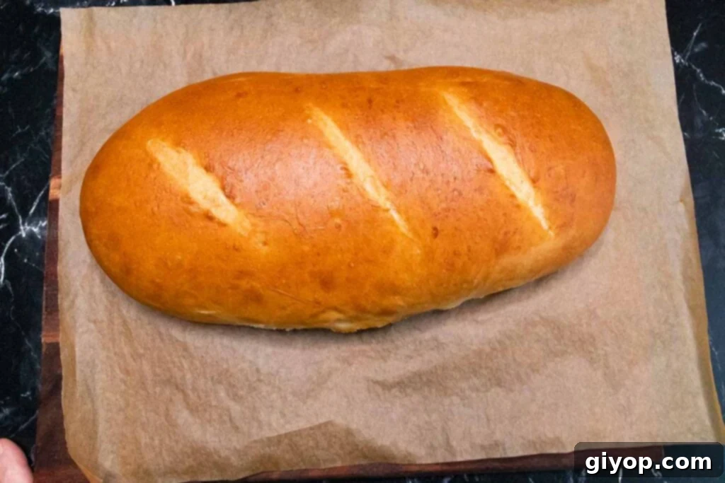 Freshly baked Italian bread on a wooden cutting board, golden and crusty.