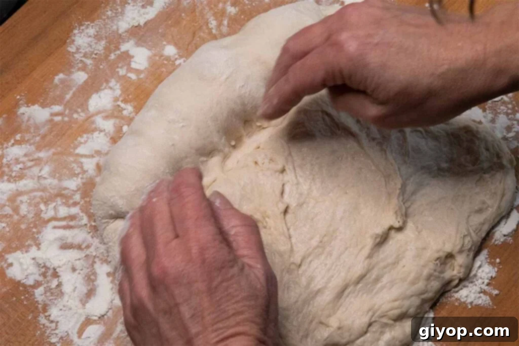 Rolling the bread dough into a tight loaf shape.