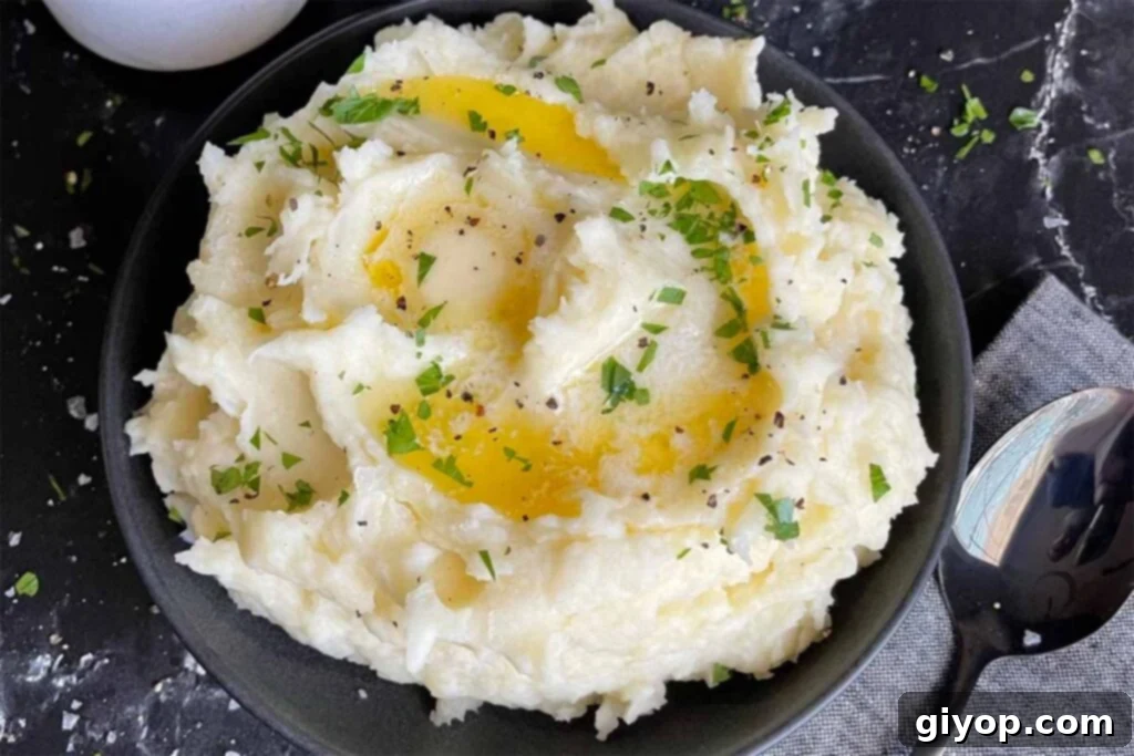 Mashed potatoes with butter in a dark bowl