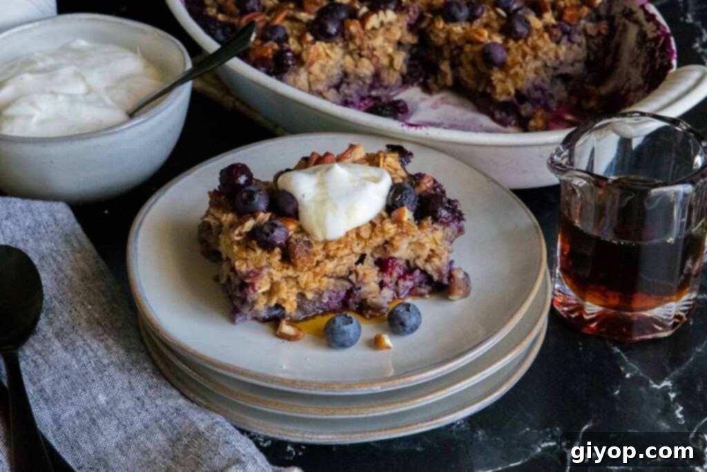 Wholesome Blueberry Baked Oatmeal 3 A delicious individual slice of blueberry baked oatmeal, perfectly golden brown and topped with fresh berries, served on a modern gray plate.
