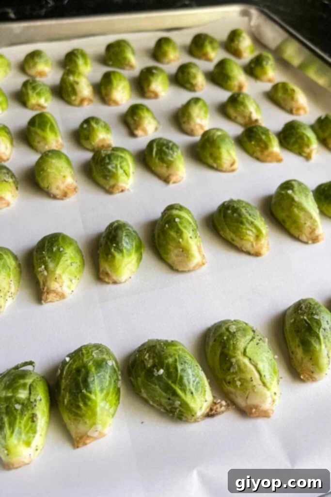 Raw brussels sprouts on a baking sheet.