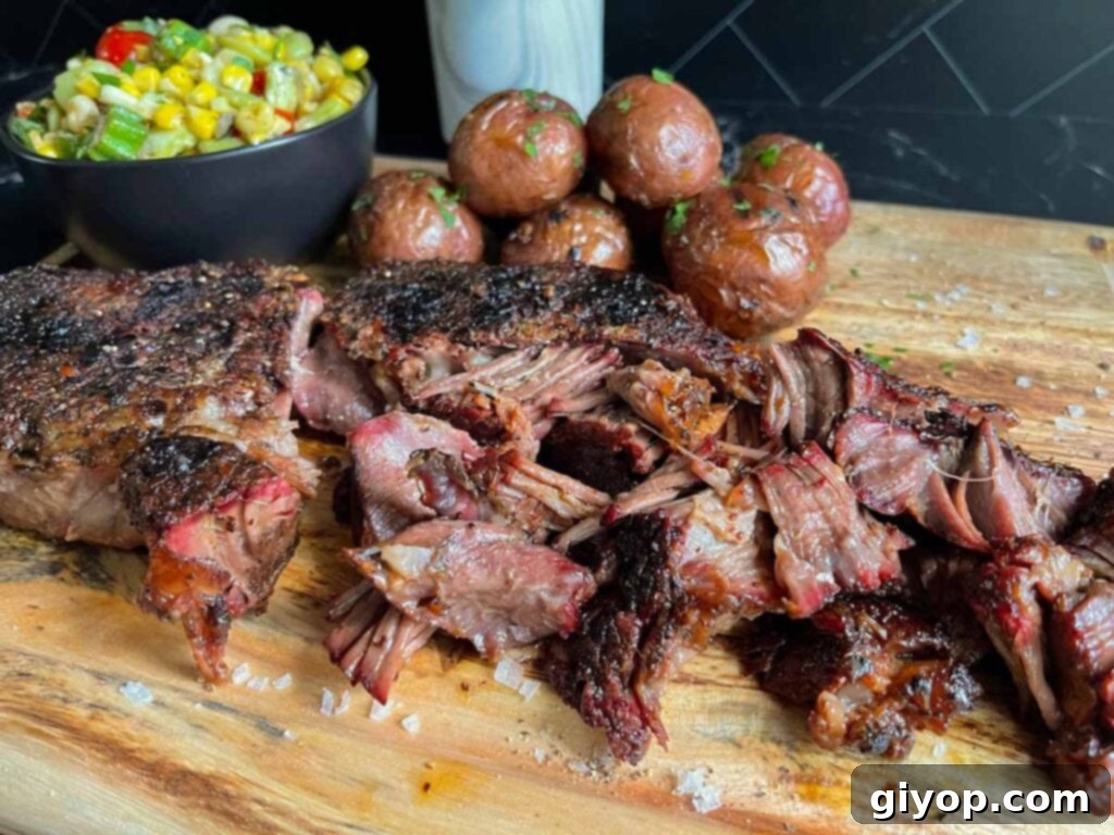 Smoked chuck roast with grilled potatoes and succotash on a wooden board.