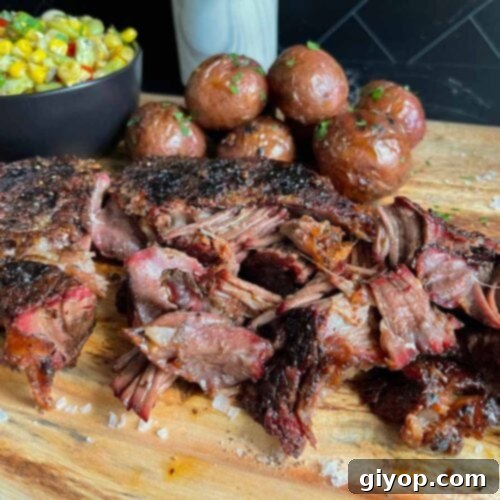 Smoked chuck roast with grilled potatoes and succotash on a wooden board.