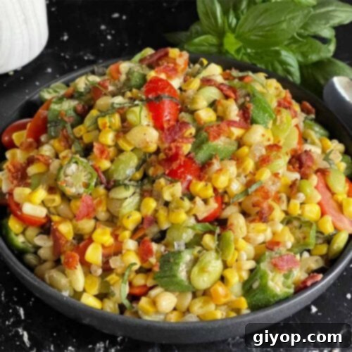 Summer succotash in a black bowl on a dark surface.