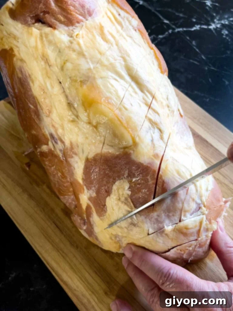Diagonal slices being cut into the ham to make a diamond pattern.