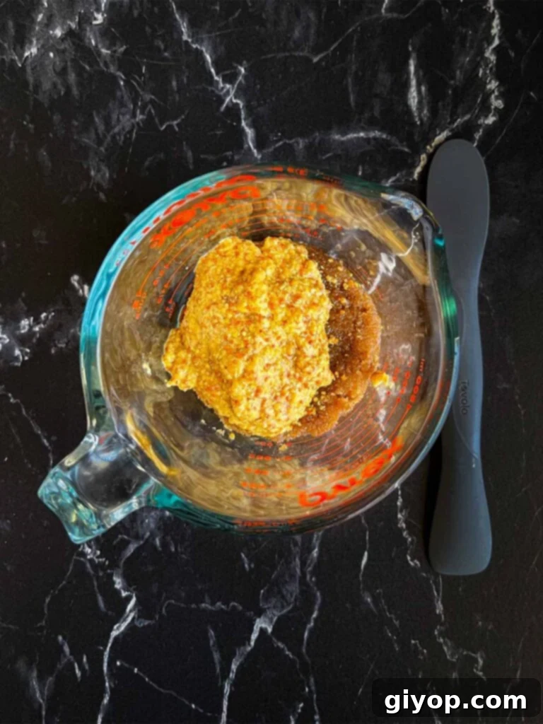 Brown sugar glaze ingredients in a glass measuring cup.