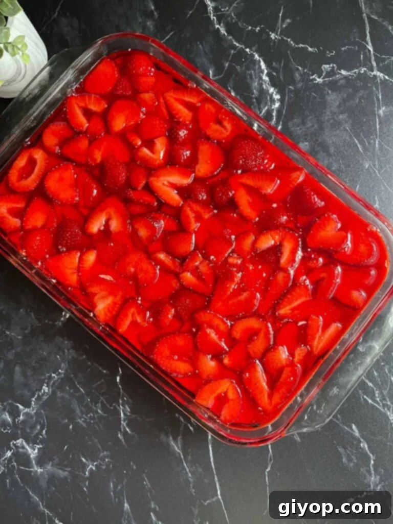 The completed strawberry pretzel salad in a 9x13 pan, with all layers assembled and ready for final refrigeration.