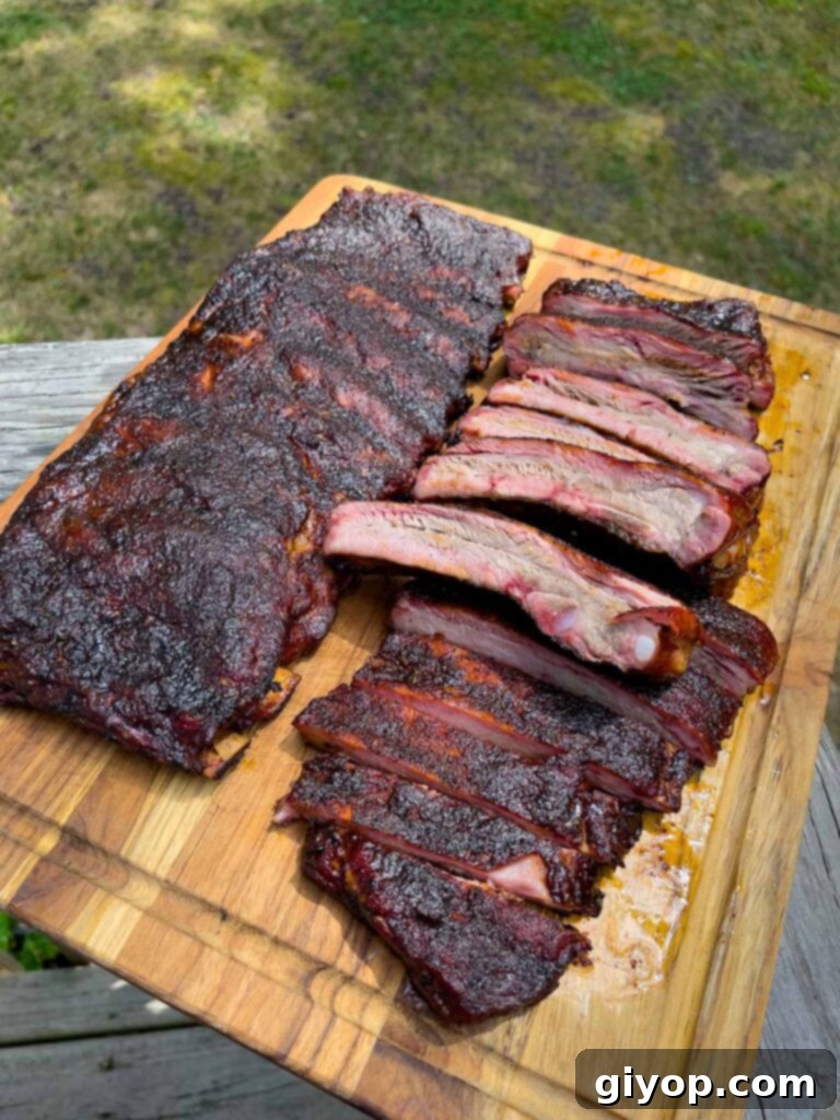 Two racks of ribs on a cutting board, one fully sliced into individual portions.