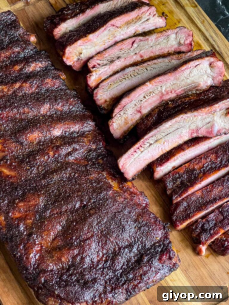 Two perfectly smoked racks of ribs displayed on a wooden cutting board.