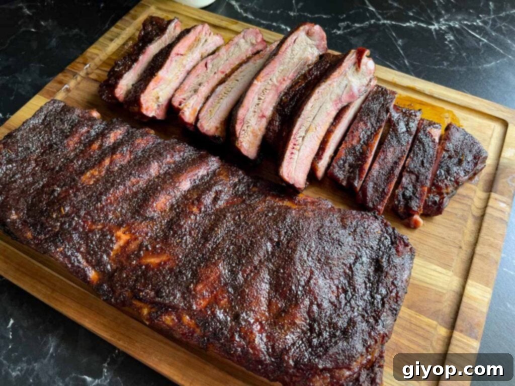 Two racks of St. Louis style ribs on a cutting board, one expertly sliced.