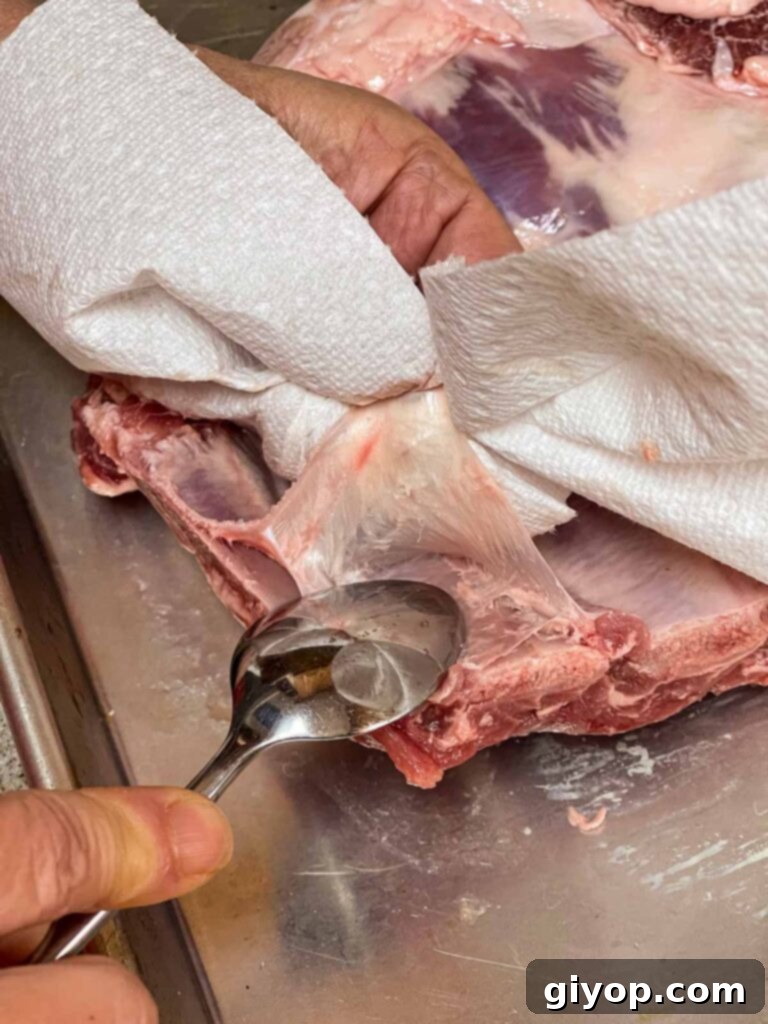 The process of carefully removing the silver skin from a rack of ribs.