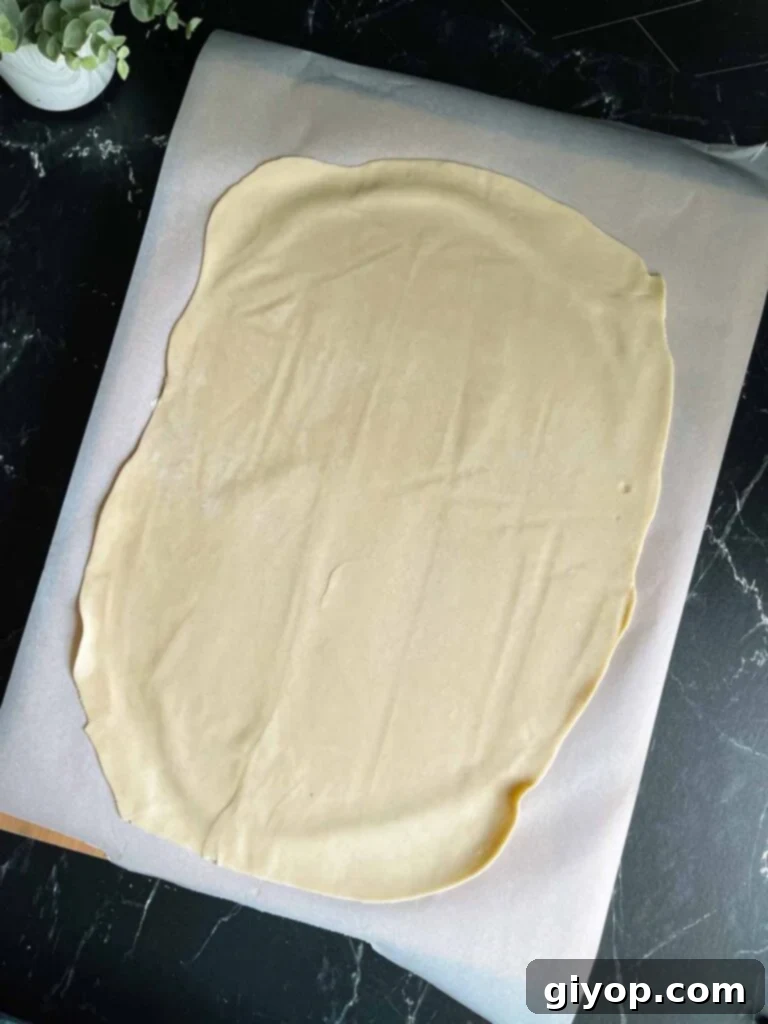 Blueberry Harvest Delight 4 A sheet of rolled-out pie dough, perfectly prepped on parchment paper and lightly floured, ready for the baking pan.