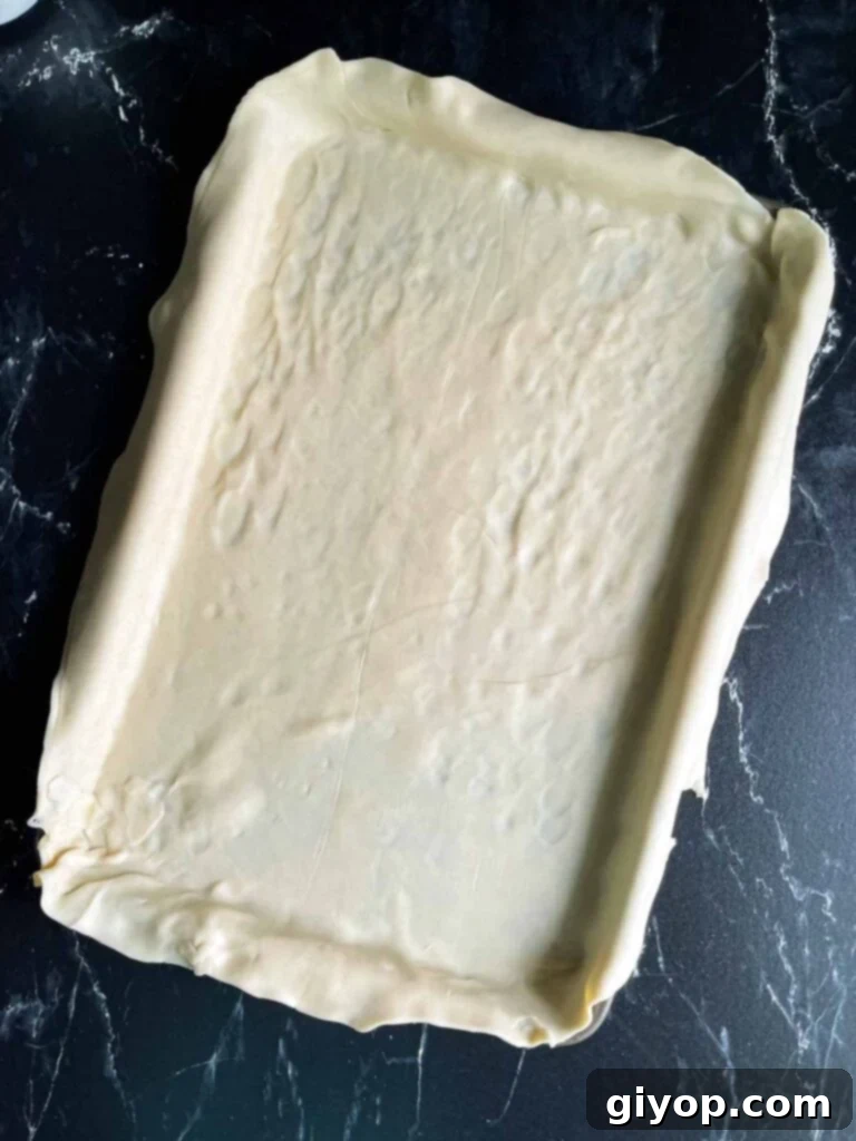 Blueberry Harvest Delight 5 A single, expansive pie crust meticulously fitted to cover the entire surface of a standard sheet pan, forming the perfect base for a slab pie.