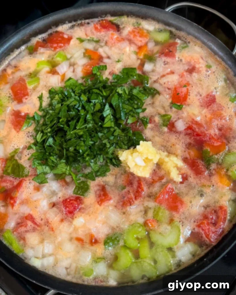 Pot of Sicilian chicken noodle soup simmering with the parsley and garlic added.