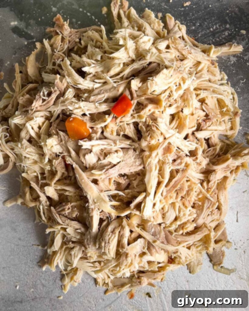 Cooked shredded chicken on a sheet pan.