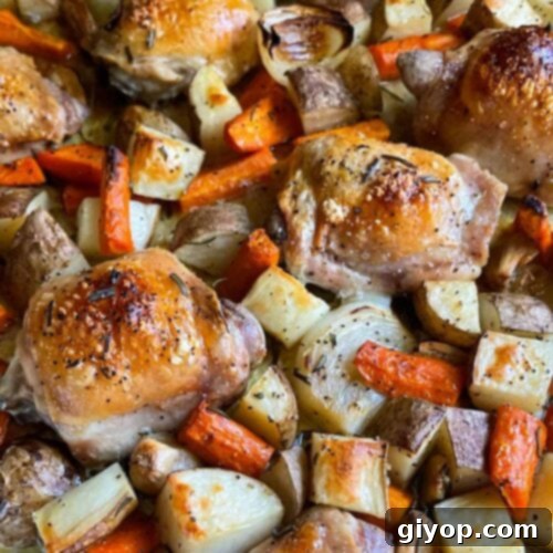One pan roasted chicken and vegetables in a foil and parchment paper lined baking sheet.