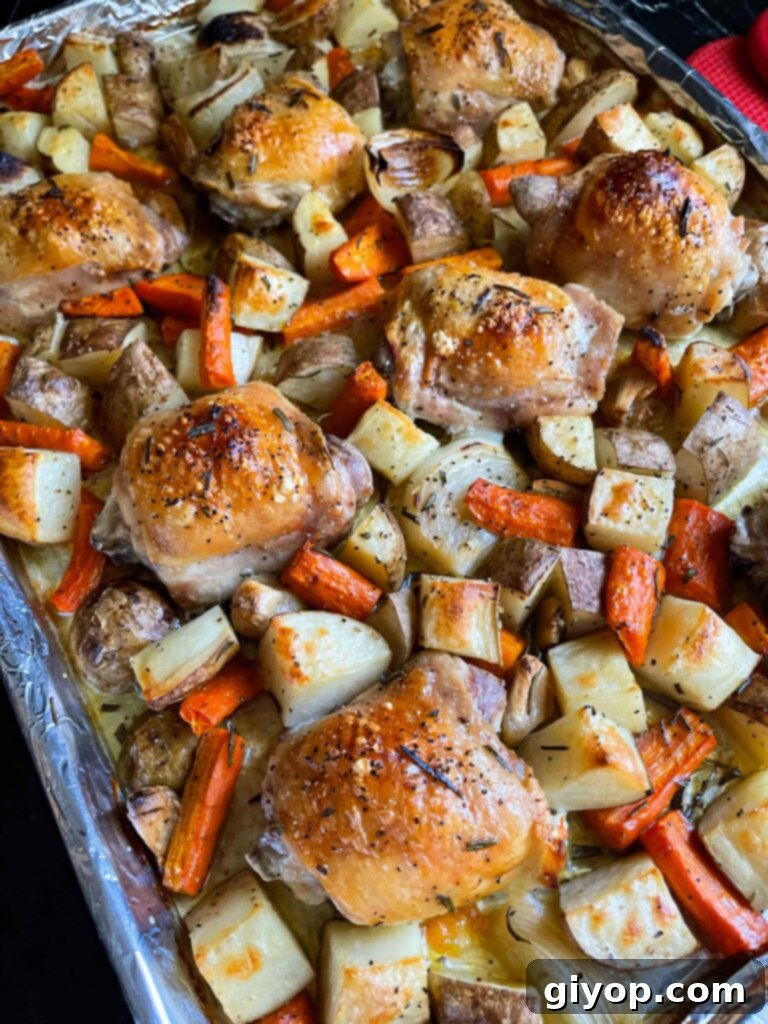 A vibrant close-up of our one-pan roasted chicken and vegetables, showcasing the golden-brown chicken and tender, colorful veggies on a lined baking sheet.