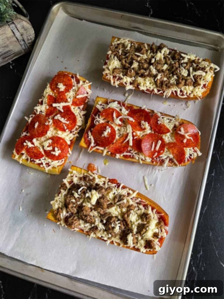 Unbaked French bread pizzas with sauce, cheese, and toppings on a baking sheet, ready for the oven.