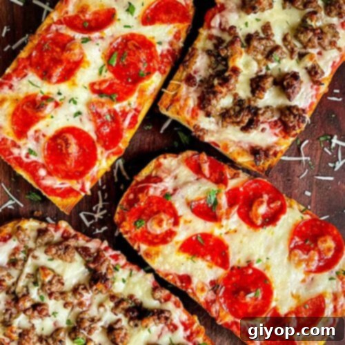 French bread pizza with pepperoni and Italian sausage on a dark wooden cutting board, presented as the recipe hero shot.