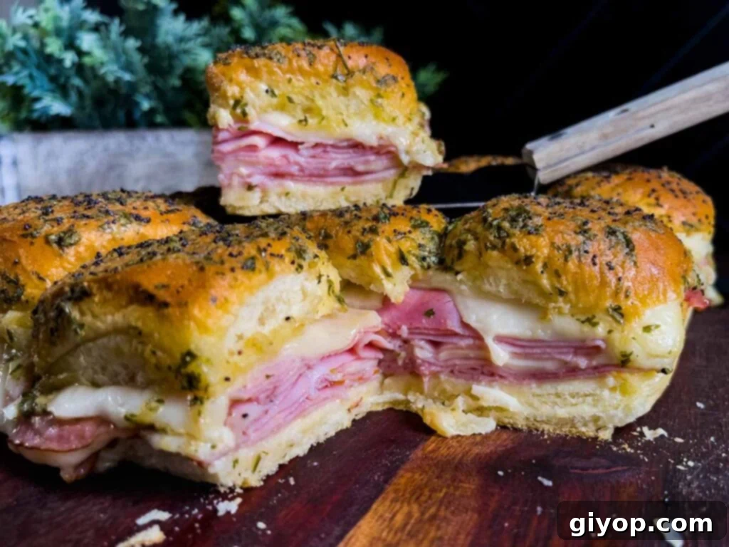 Ham and cheese sliders on a wooden cutting board.