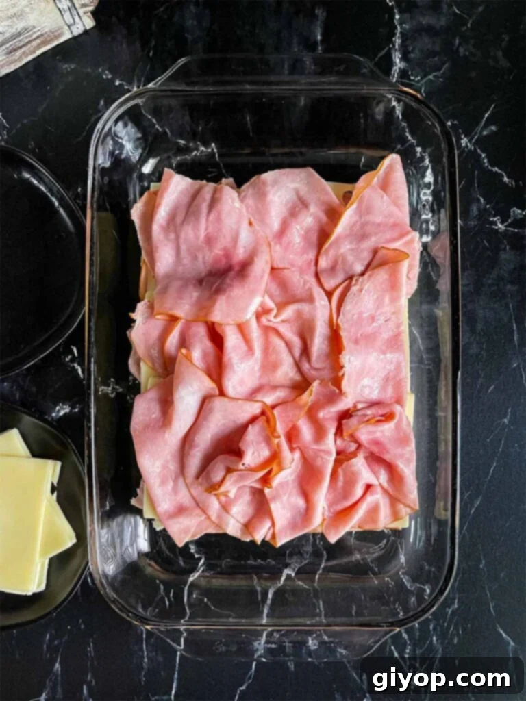 Assembling the sliders in a glass baking dish.
