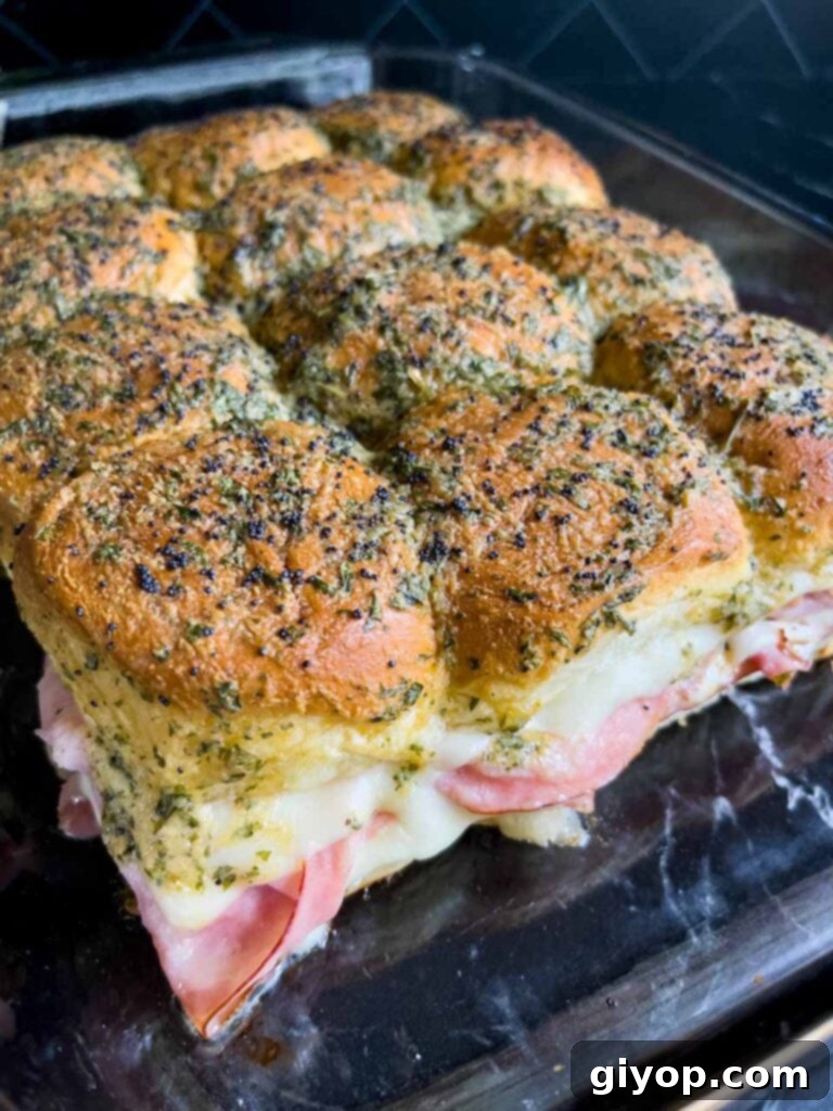 Ham and swiss cheese sliders right out of the oven in a glass baking dish.