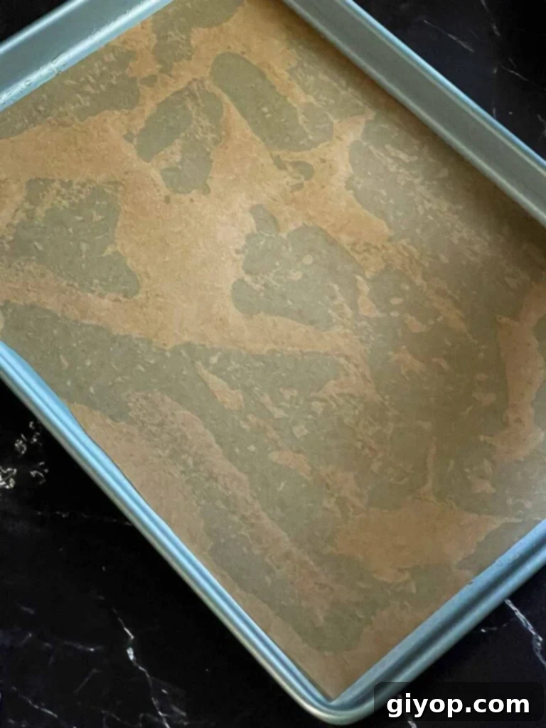 A sheet of parchment paper placed on an olive oil-lined baking sheet, ready for the focaccia dough.