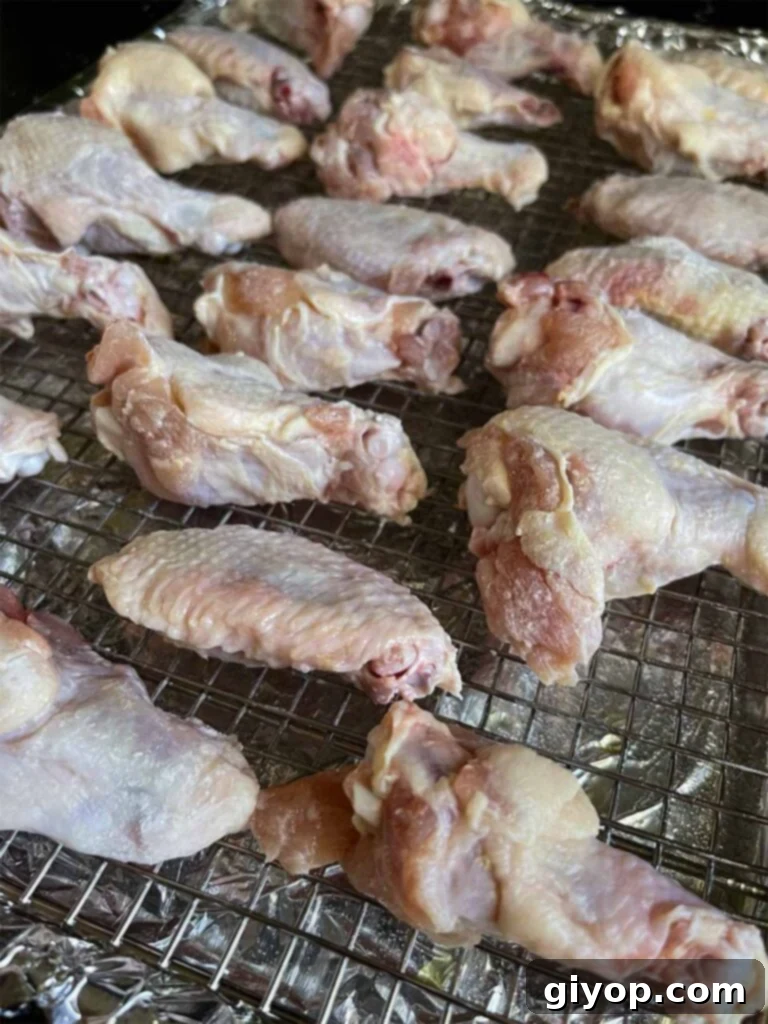 Golden Crispy Asian Oven Wings 5 Raw chicken wings meticulously arranged in a single layer on a wire rack, ready for oven baking.
