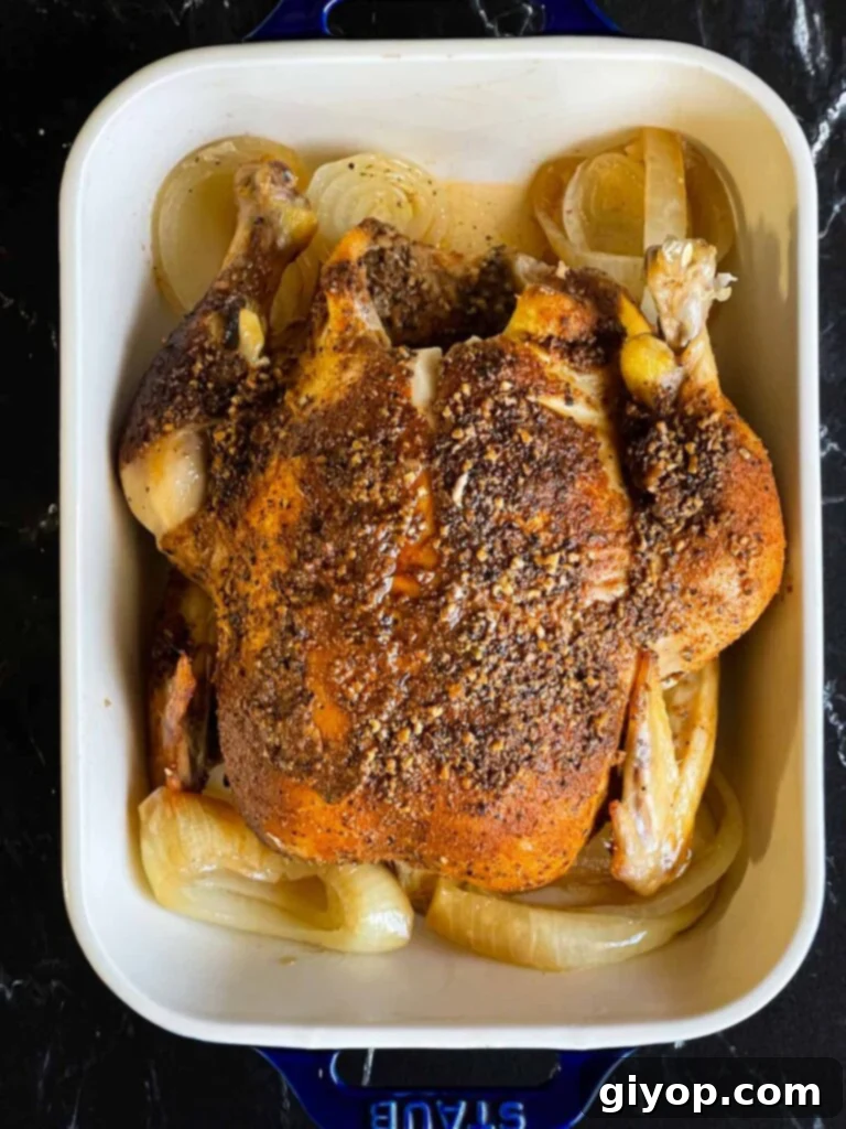 Slow cooker roasted chicken served in a rustic dish on a dark background, garnished with herbs.