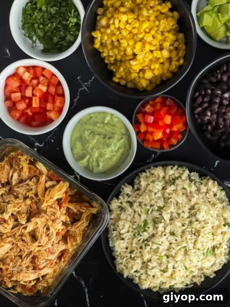 A colorful spread of fresh ingredients, including crisp lettuce, golden corn, dark black beans, vibrant tomatoes, and creamy avocado slices, all ready for a chicken burrito bowl.