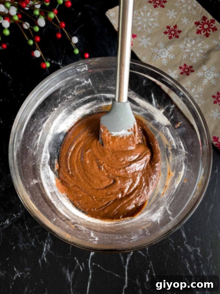 Smooth, rich chocolate crinkle cookie batter in a glass bowl, perfectly mixed and ready for chilling.