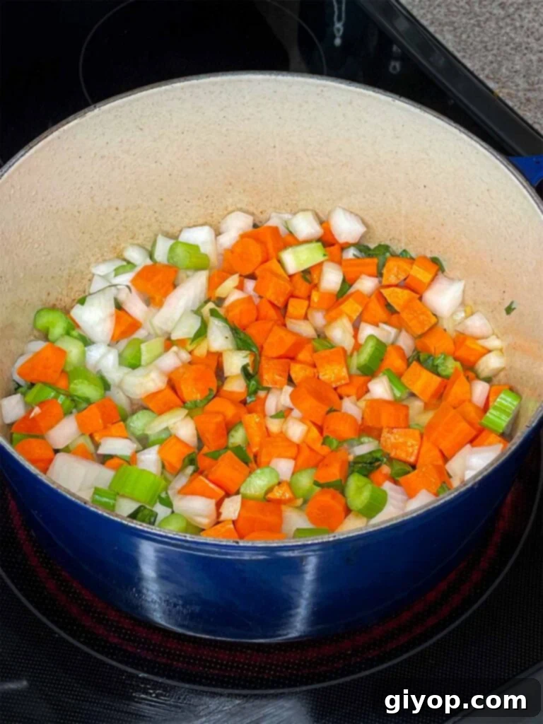Chopped celery, carrots, and onions (mirepoix) are added to a Dutch oven, sautéing gently after the beef has been removed.