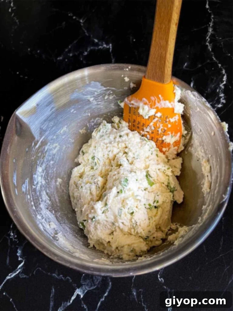 Freshly mixed dumpling dough in a stainless steel bowl, showing its soft and slightly sticky texture.