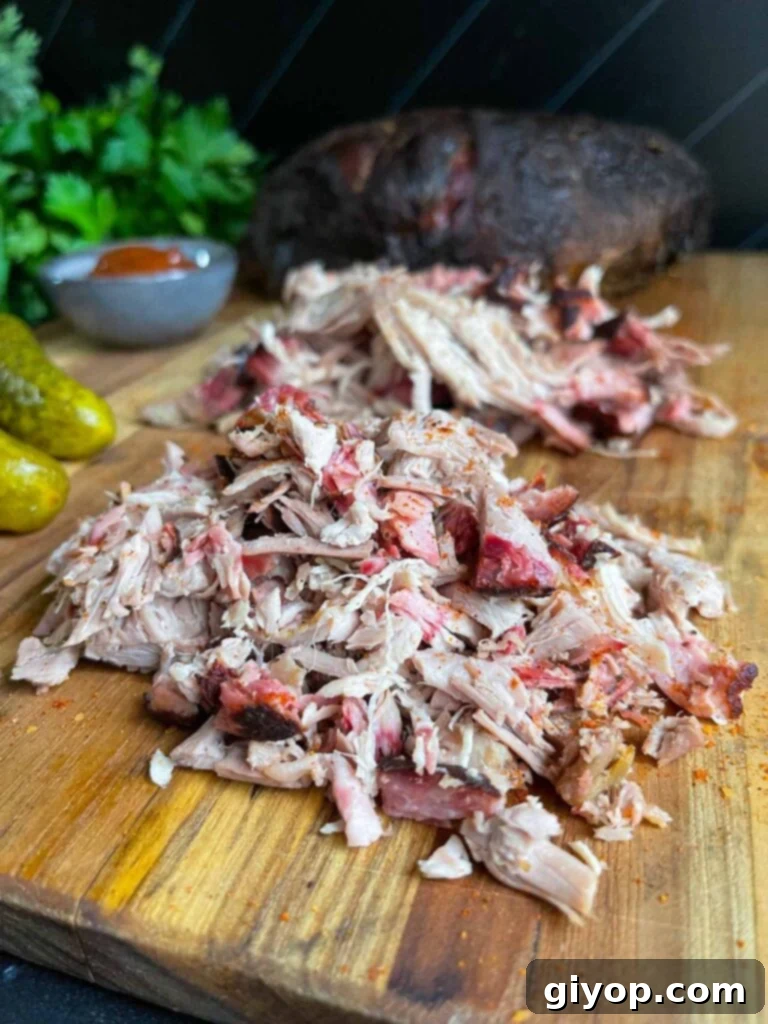 Ultimate Pork Shoulder Brine 6 Chopped and shredded pork butt on a wooden cutting board, ready to be served.