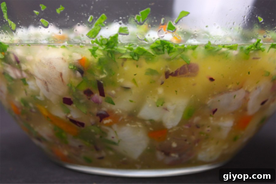 Ceviche in two green margarita glasses garnished with a lime slice and tortilla chips.