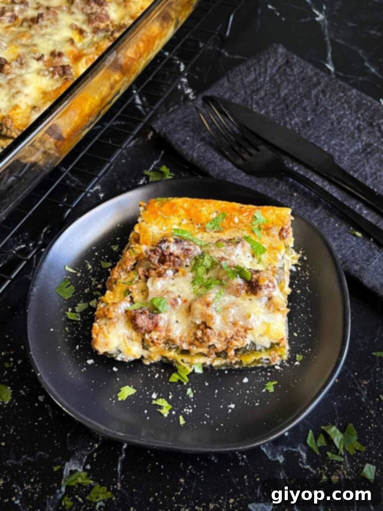 Cheesy Chile Relleno Bake 14 A serving of chile relleno casserole on a dark plate with the casserole in the background.