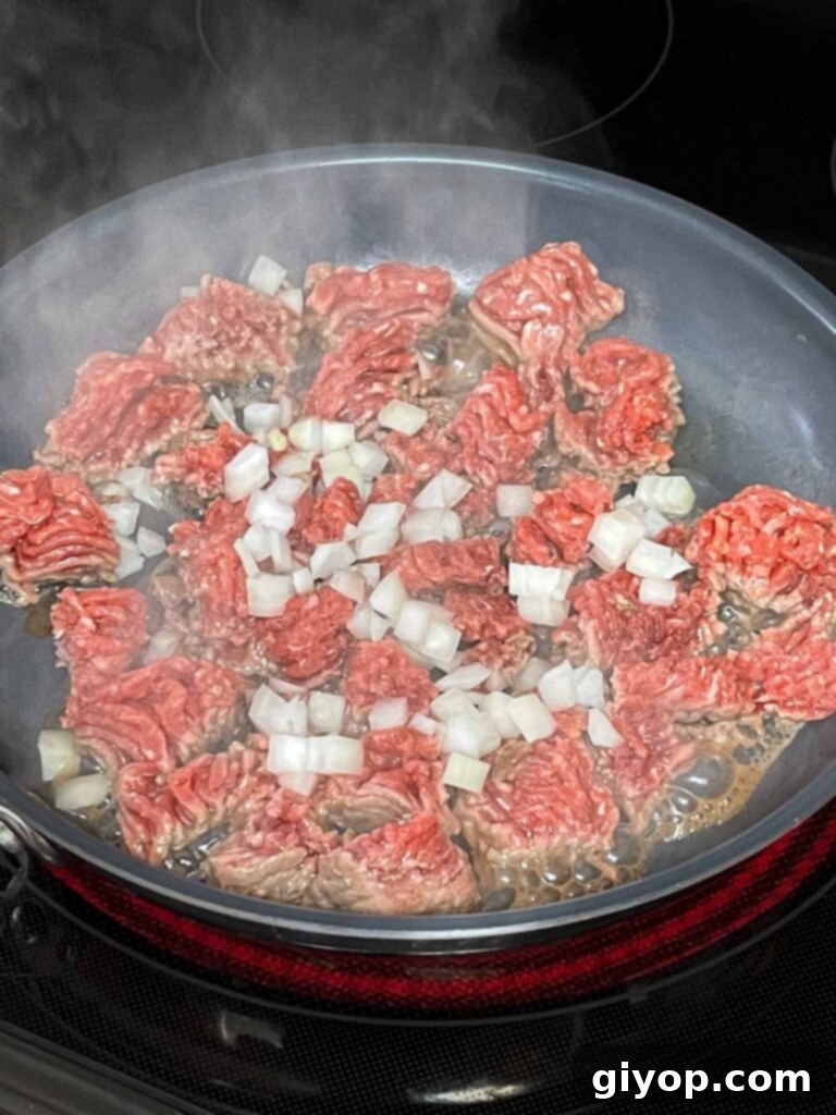 Cheesy Chile Relleno Bake 6 Ground beef with onions browning in a skillet.
