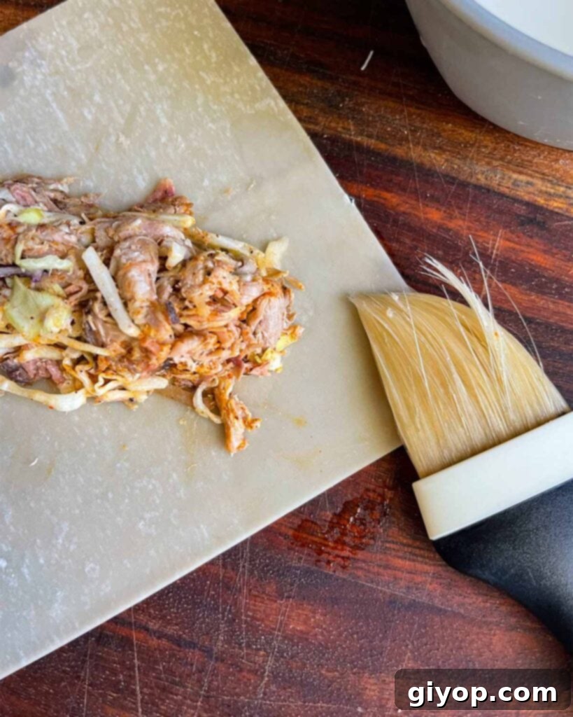 Dampening the edges of an egg roll wrapper.