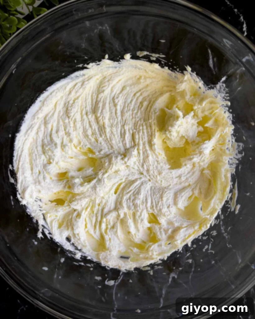 Creamy ricotta cheese and mascarpone cheese beautifully blended together in a clear glass mixing bowl, ready for the next ingredients.