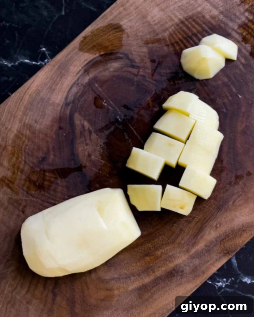 Homestyle Southern Potato Salad 4 Russet potato diced on a wooden cutting board.