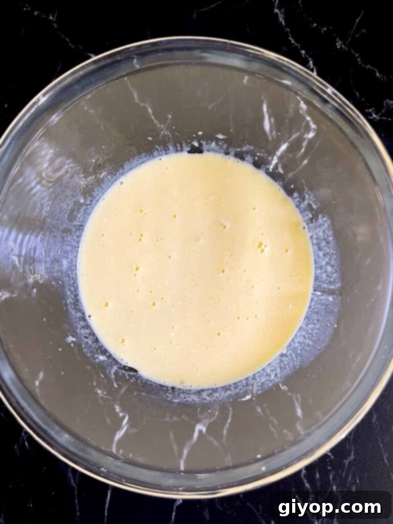 Wet ingredients for Mississippi Mud Cake expertly combined in a glass mixing bowl, showcasing a smooth texture.