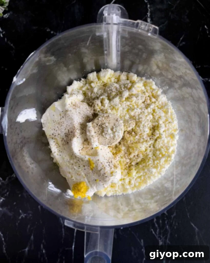 Whipped feta ingredients in the bowl of a food processor.