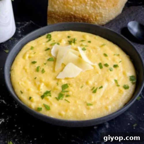 Effortless Creamy Polenta Perfection 11 Polenta in a dark bowl garnished with chopped parsley and parmesan cheese.