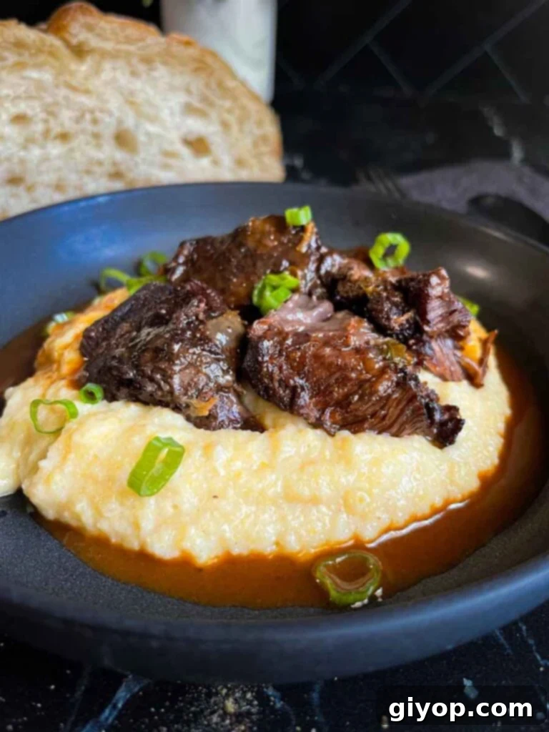 Effortless Creamy Polenta Perfection 3 Braised beef cheek on a bed of polenta in a dark bowl.