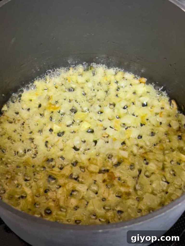 Effortless Creamy Polenta Perfection 5 Olive oil heating in a pot on the stovetop.