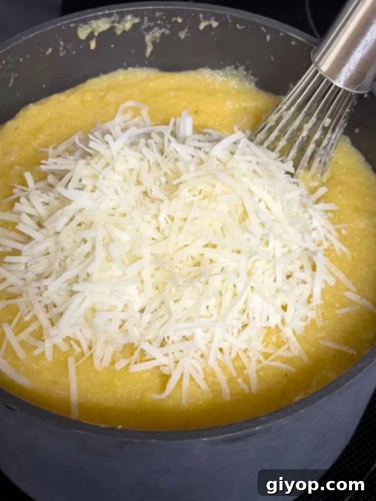 Effortless Creamy Polenta Perfection 8 Adding parmesan cheese to polenta.